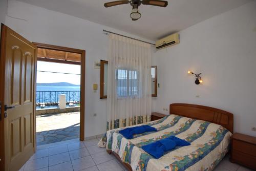 a bedroom with a bed and a view of the ocean at Thea Studios in Kalamakia