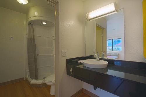 a bathroom with a sink and a toilet and a mirror at North Charleston Lodge in Charleston
