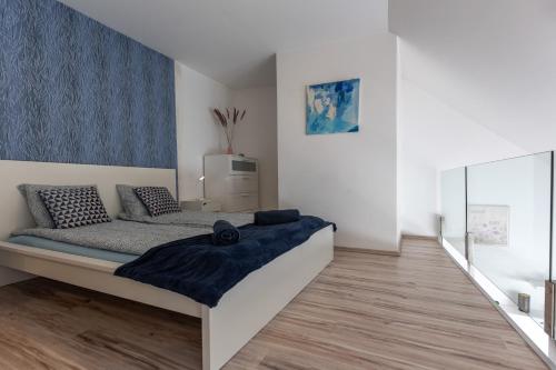 a bedroom with a bed with a blue blanket on it at PRTR Apartment w/ FREE parking in Budapest