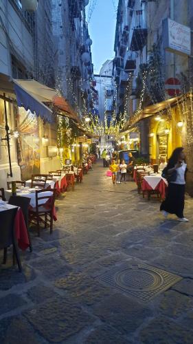 a city street with tables and chairs and buildings at White Home Quartieri Spagnoli in Naples