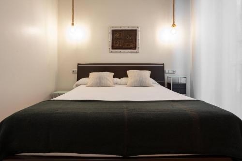 a bedroom with a large bed with two pillows at smart urban in San Sebastián