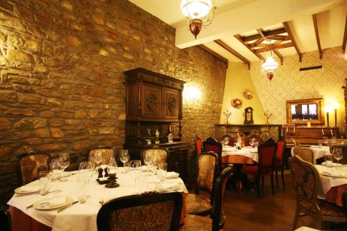Guesthouse Agonari في Sklíthron: مطعم بطاولات وكراسي وجدار حجري