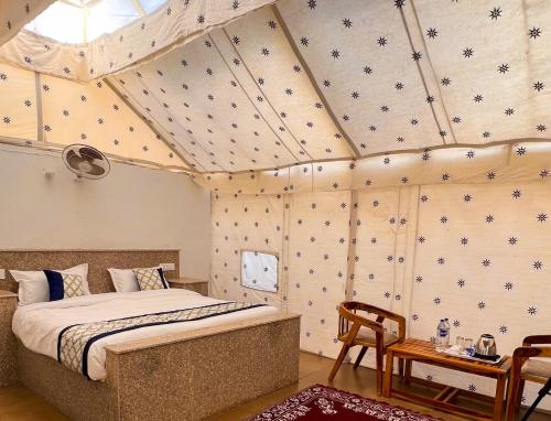 een slaapkamer met een bed in een kamer bij NK Desert Camp Jaisalmer in Sām