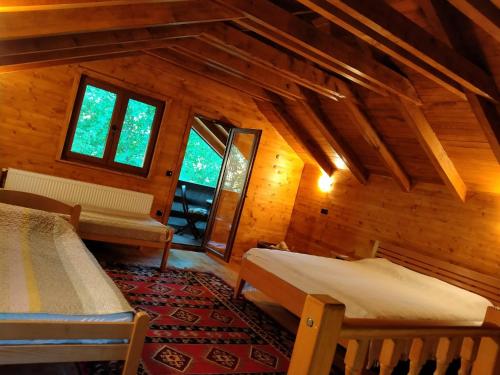 a room with two beds and windows in a cabin at Kuća u šumi - Forest house near National park Una - Air Spa Lohovo in Bihać