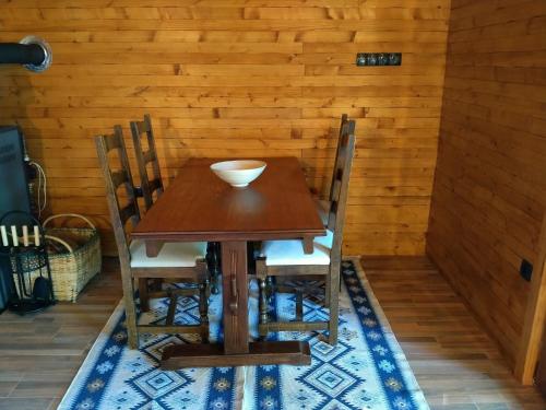 a wooden table with chairs and a bowl on it at Kuća u šumi - Forest house near National park Una - Air Spa Lohovo in Bihać
