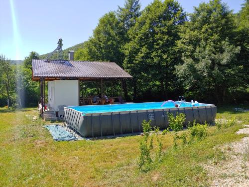 a large swimming pool in front of a gazebo at Kuća u šumi - Forest house near National park Una - Air Spa Lohovo in Bihać