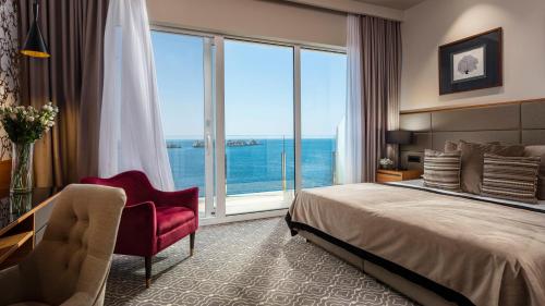 a hotel room with a bed and a large window at Royal Neptun Hotel in Dubrovnik