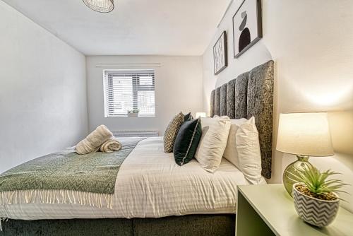a bedroom with a bed and a table with a lamp at Guest Homes - Rose Cottage in Worcester