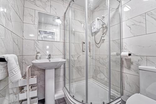 a bathroom with a shower and a sink and a toilet at Guest Homes - Rose Cottage in Worcester