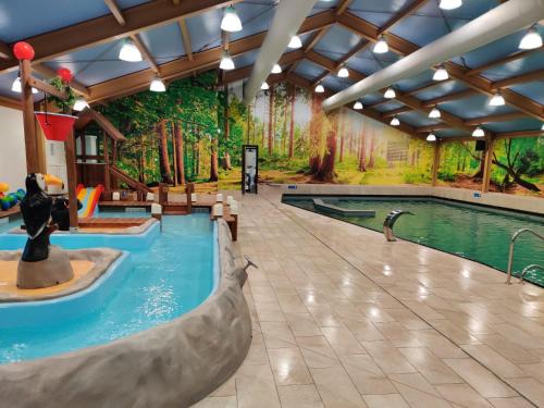 a large indoor pool with a water park mural at EuroParcs De Utrechtse Heuvelrug in Maarn