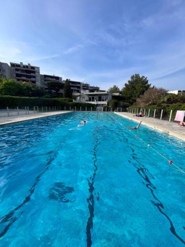 duży basen z niebieską wodą w obiekcie CAP6 Bel appartement vue magnifique mer, Piscine Tennis T3 refait à neuf w Cassis