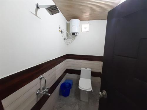 a small bathroom with a toilet in a stall at Lake Haven Resort, Sari, Chopta in Sari