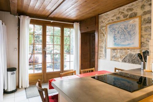 une cuisine avec une table et une grande fenêtre dans l'établissement Chalet Credence Morzine Outdoor Hot Tub Sleeps 19, à Morzine
