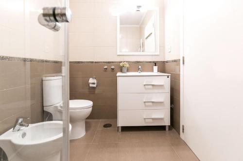 La salle de bains est pourvue de toilettes, d'un lavabo et d'un miroir. dans l'établissement Casa Amarela - Countryside Villa by LovelyStay, à Alcobaça