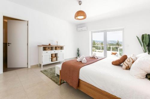 biała sypialnia z dużym łóżkiem i oknem w obiekcie Casa Amarela - Countryside Villa by LovelyStay w mieście Alcobaça