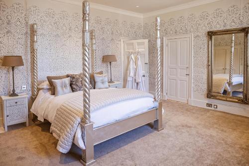 a bedroom with a four poster bed and a mirror at Gileston Manor Luxury B&B in Barry