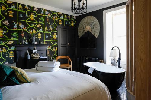 1 dormitorio con cama, bañera y pared en Gileston Manor Luxury B&B en Barry