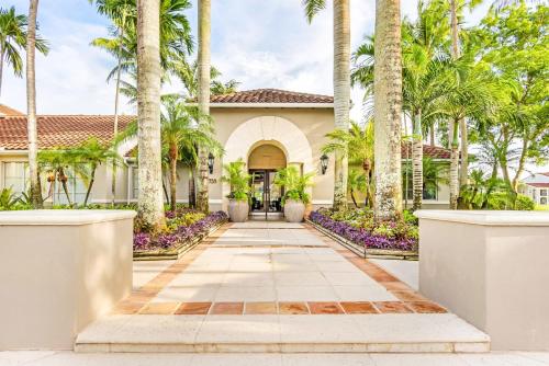 ein Herrenhaus mit Palmen und einem Gehweg in der Unterkunft Stunning & Spacious Apartments at Miramar Lakes in South Florida in Miramar