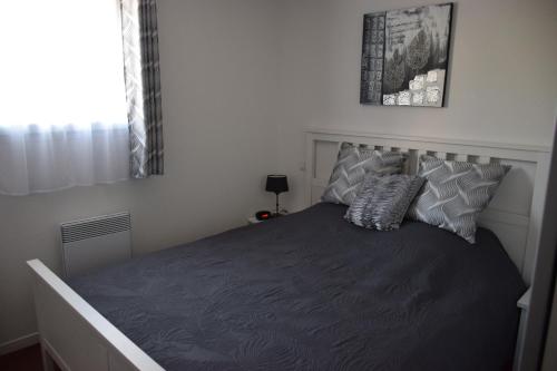 1 dormitorio con 1 cama grande con sábanas y almohadas grises en location maison à Cajarc 46160 (Lot), en Cajarc