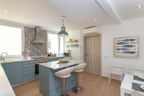 a kitchen with blue cabinets and white countertops at Casa Angelica in Praia do Carvoeiro