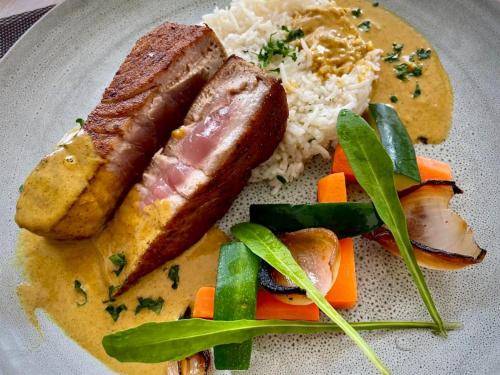 a plate of food with sausage and rice and vegetables at Ranthari Hotel and Spa Ukulhas Maldives in Ukulhas