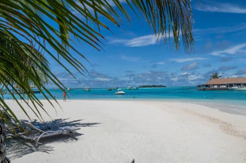a beach with two lounge chairs and the ocean at Holiday Inn Resort Kandooma Maldives - Kids Stay & Eat Free and DIVE FREE for Certified Divers for a minimum 3 nights stay in Guraidhoo