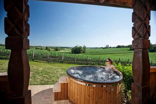 a woman sitting in a hot tub in a yard at Tiny house AMBAR in Starčevljani