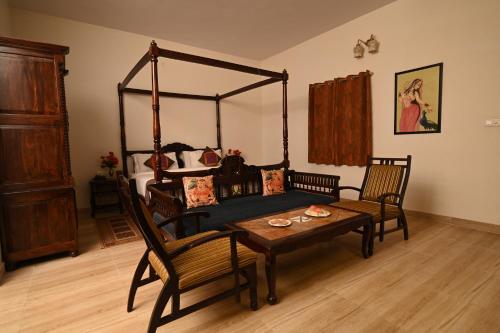 1 dormitorio con 1 cama, mesa y sillas en ClarksInn Suites Ranthambhore, en Sawāi Mādhopur