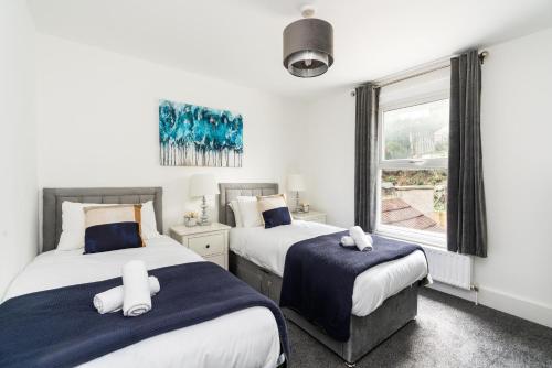 a bedroom with two beds and a window at Dressed To Impress 2 bed house in Heart of Croydon Photo ID Required in Croydon