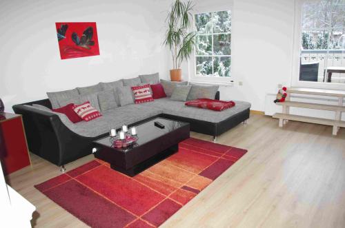 - un salon avec un canapé et un tapis rouge dans l'établissement Ferienwohnung Sonneneck, à Wernigerode