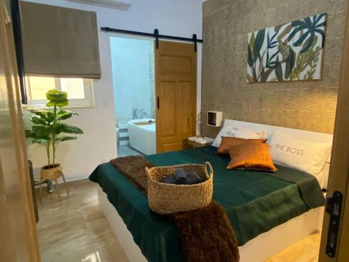 a bedroom with a bed with a basket on it at GOZO TA CENC RESIDENCE WITH COMMUNAL POOL in Sannat