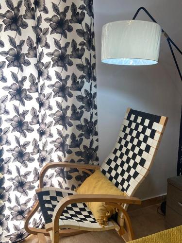 a lamp and a chair with a flower pattern on a wall at GOZO TA CENC RESIDENCE WITH COMMUNAL POOL in Sannat