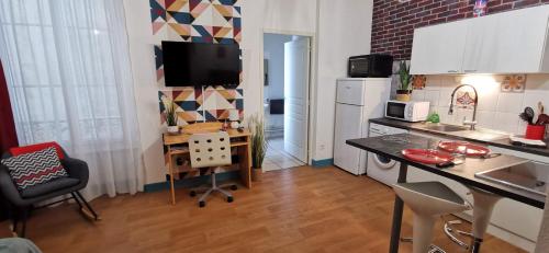 eine Küche mit Tisch und Arbeitsplatte in der Unterkunft Le Lucerne, entre thermes et centre ville-lamaisondefrancois03 in Vichy