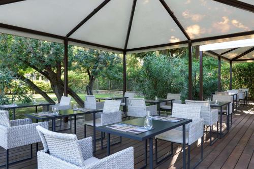 a restaurant with tables and white chairs on a deck at Best Western Park Hotel Continental in San Donà di Piave