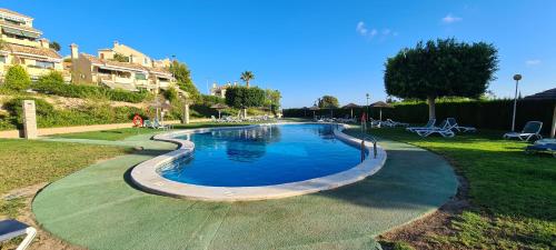 duży basen w parku z budynkami w obiekcie Apartment Campoamor Descansa w mieście Campoamor