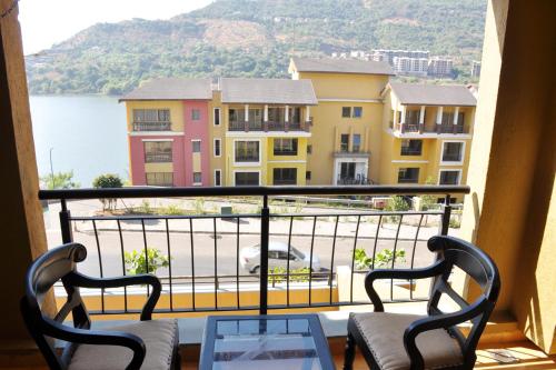 d'un balcon avec vue sur l'eau et les bâtiments. dans l'établissement 2BHK Lake View Apartment, à Lavasa