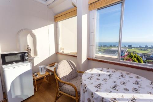 Villa Marina Guest House في كيب تاون: غرفة بسرير وطاولة ونافذة