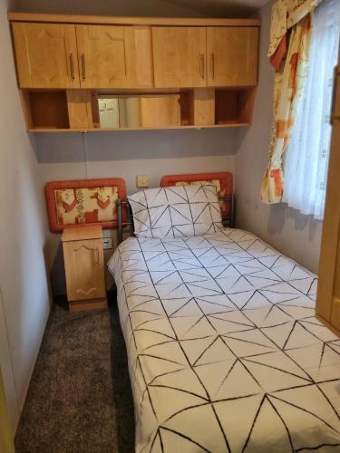 ein kleines Schlafzimmer mit einem Bett in einem Zimmer in der Unterkunft Quite 3 Bedroom Static Caravan in Sidcup