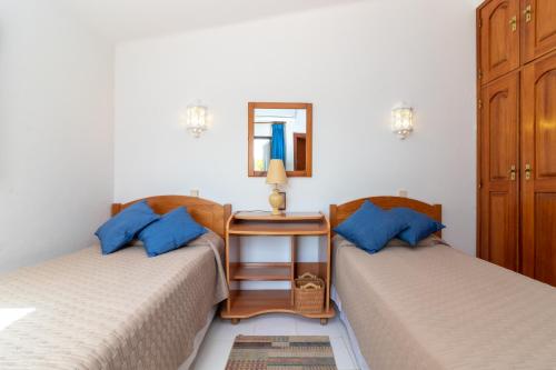 sypialnia z 2 łóżkami i stołem z lustrem w obiekcie Casa Santa Barbara w mieście Carvoeiro