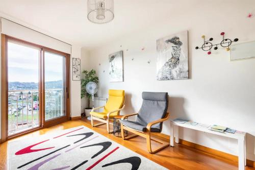 sala de estar con 2 sillas y mesa en APT SOLEADO y SILENCIOSO - GARAJE- A 17 min andando del centro de Pontevedra, en Pontevedra