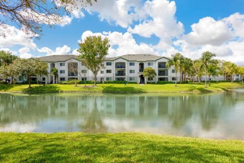 un edificio de apartamentos con un estanque frente a él en Bright and Modern Apartments at Palm Trace Landings in South Florida, en Davie