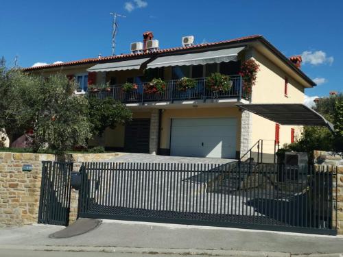 a house with a fence in front of it at Apartments Tomišić in Koper