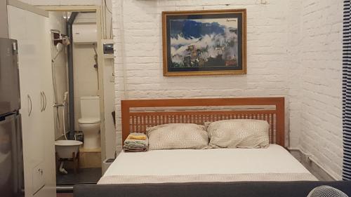 a bedroom with a bed and a picture on the wall at Best Price Hồ Gươm Apartments for Long Stay in Hanoi