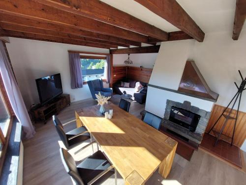 a living room with a wooden table and a fireplace at Ferienhaus Sonnendeck in Simmerath