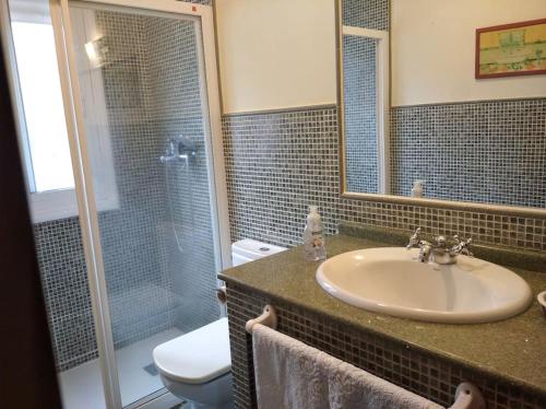 W łazience znajduje się umywalka, prysznic i toaleta. w obiekcie Casita con terreno a 10 minutos del centro de Vigo w mieście Moaña