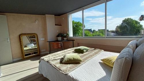 Plurienにあるle Colibri "3 étoiles"のベッドルーム1室(ベッド1台、大きな窓付)
