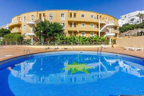 a large swimming pool in front of a building at Sunshine by the ocean 1BR apartment COSTA ADEJE by Aqua Vista Tenerife in Adeje