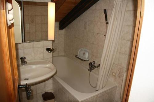 a bathroom with a sink and a tub and a shower at Plazzetta 23 in Sent