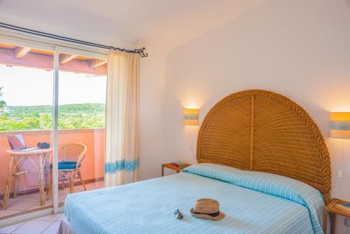 una camera da letto con un letto con un cappello sopra di Residence Fenicia a Villasimius