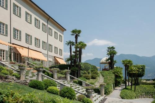 a view of a building with stairs and palm trees at Passalacqua in Moltrasio